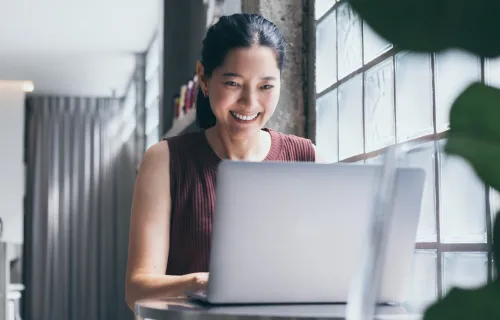 Woman smiling, working at laptop
