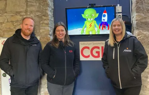 Members of CGI and DangerPoint standing infront of K-os an interactive alien on a TV 